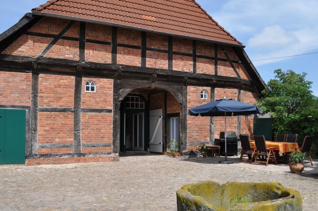 Sonnige, windgeschützte Terrasse mit Gartenmöbeln und großem Gasgrill