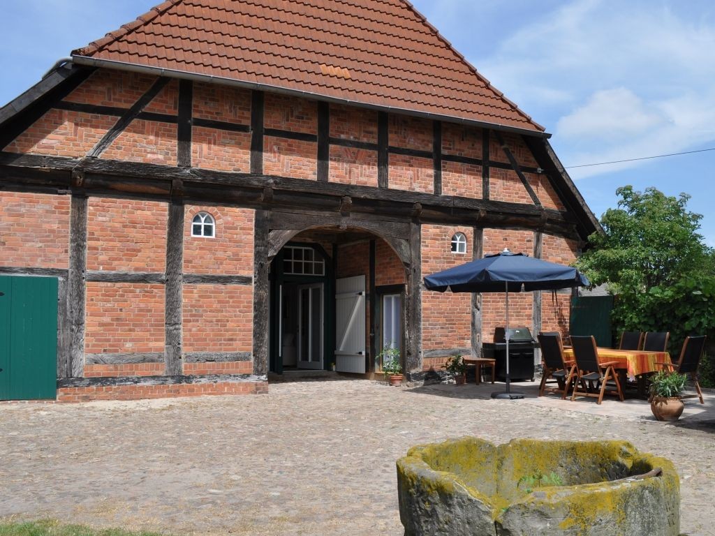 Sonnige, windgeschützte Terrasse mit Gartenmöbeln und großem Gasgrill